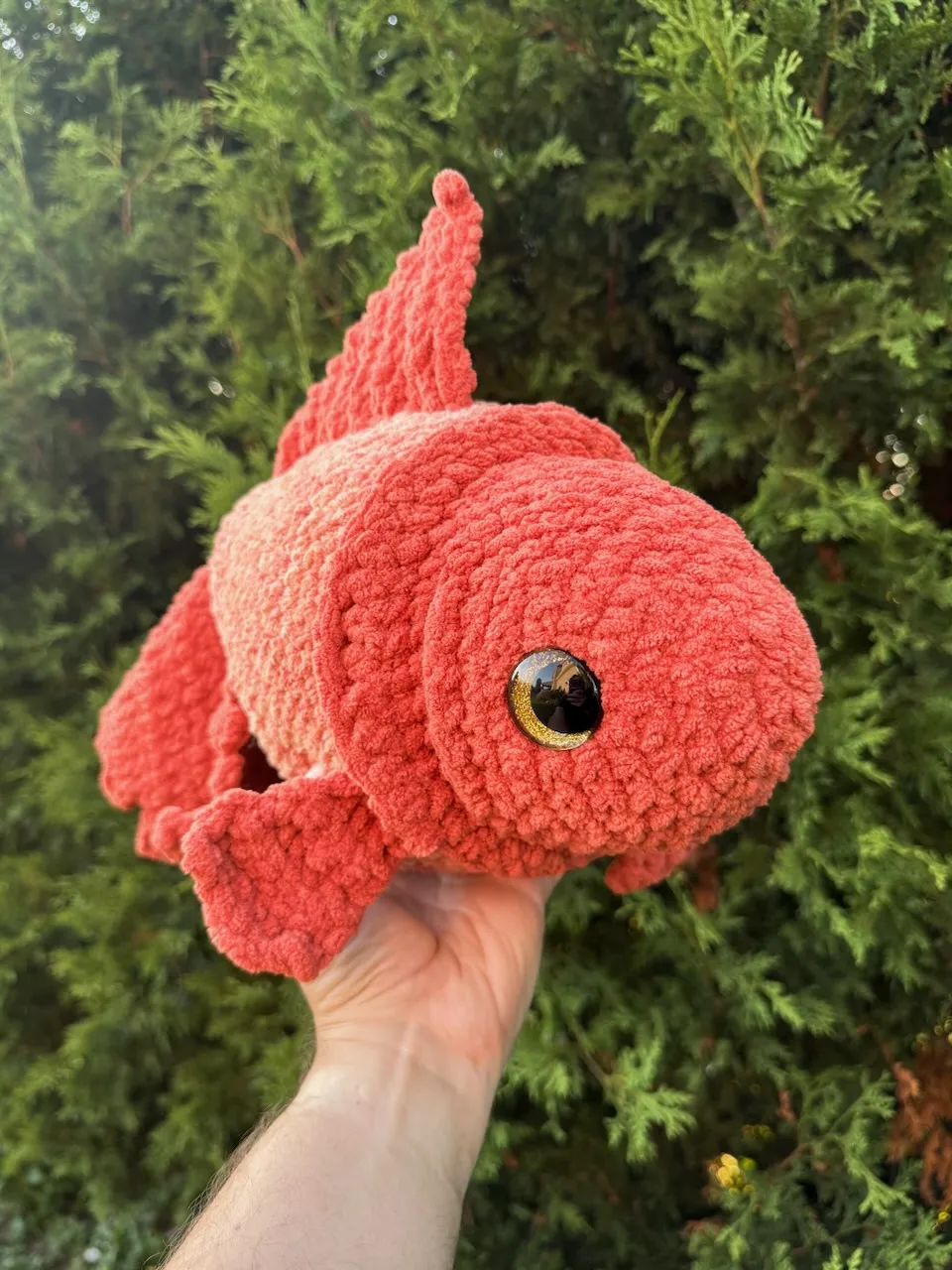 A crochet goldfish in amber yarn
